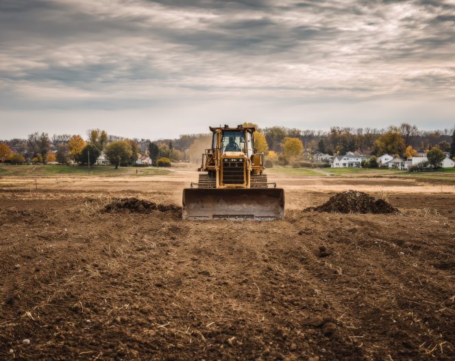 bulldozer leveling construction site for new development under a cloudy sky ensuring level ground and proper drainage photo